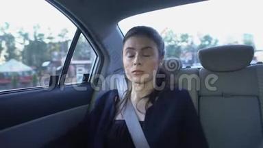 昏昏欲睡的女人在出租车里醒来，环顾四周，工作累坏了，精疲力竭